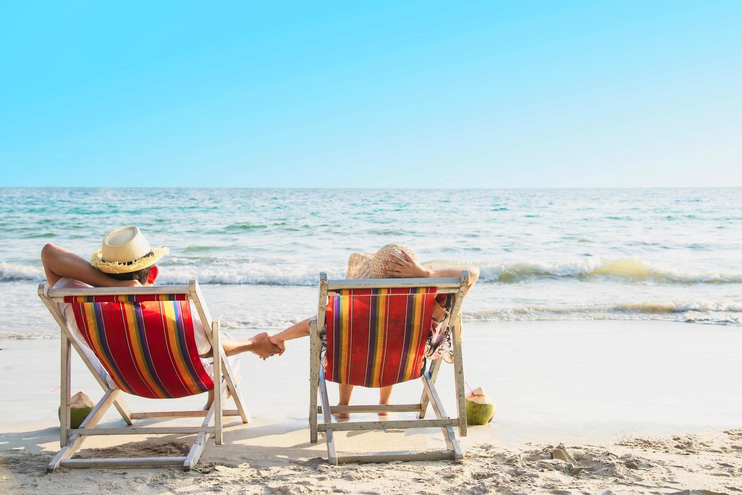 relaxe o casal deitou-se no chiar da praia com fundo de ondas do mar - homem e mulher têm férias no conceito de natureza do mar foto