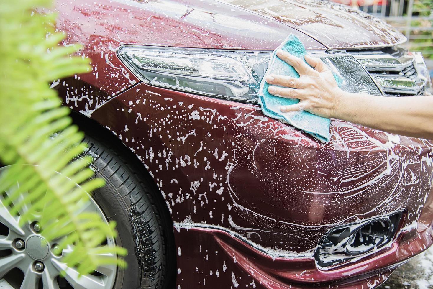 homem lavar carro usando shampoo - conceito de cuidado de carro de vida diária foto