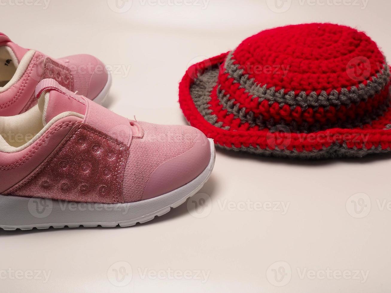 foto de cor vermelha com chapéu de crochê de listras cinza e um par de sapatos rosa