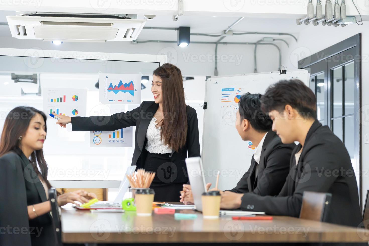 linda empresária dá relatório, apresentação para seus colegas de trabalho na sala de conferências, ela mostra gráficos. profissional de negócios feminino de sucesso. foto