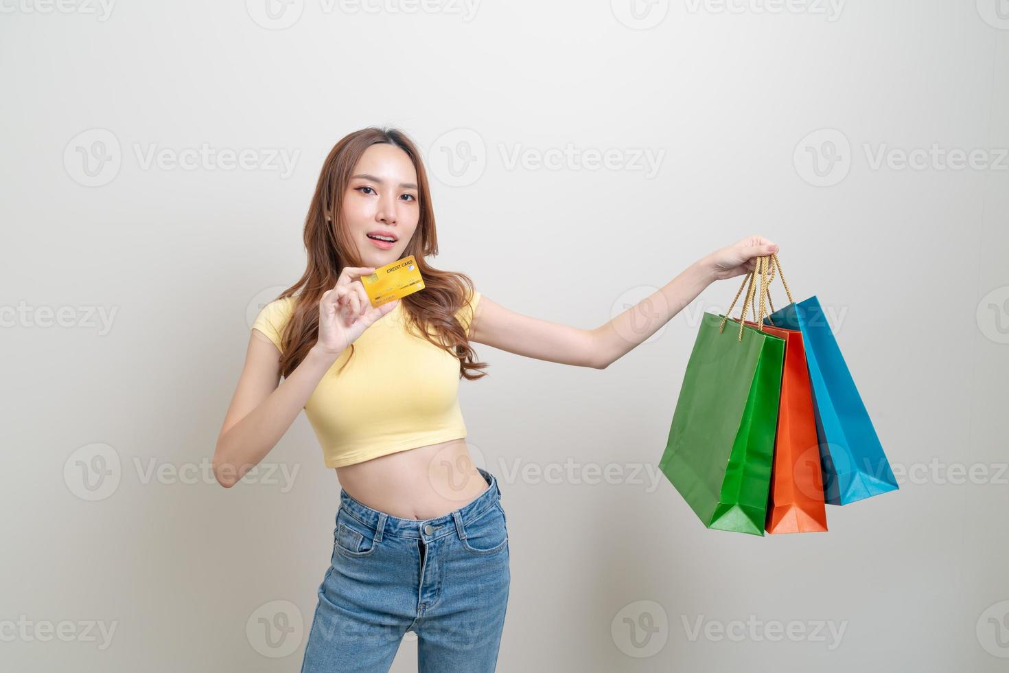 retrato de uma mulher bonita segurando uma sacola de compras e um cartão de crédito foto