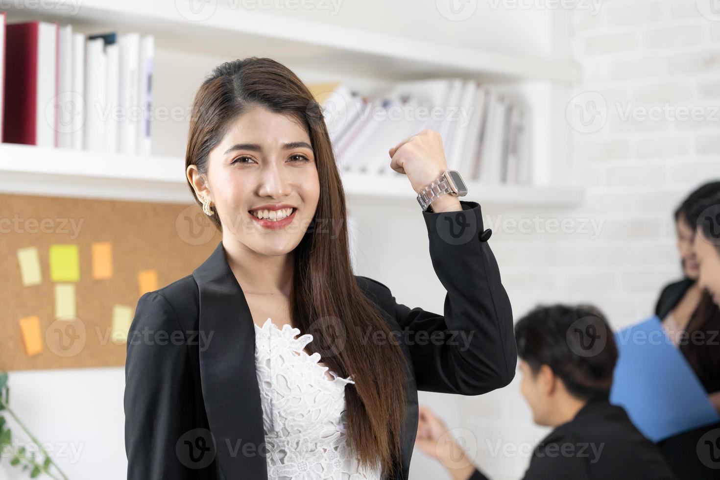 linda mulher de negócios asiáticos profissional sorri felizmente bem sucedida enquanto olha para a câmera. mulher de negócios está de pé e alegre com orgulho de seu sucesso foto