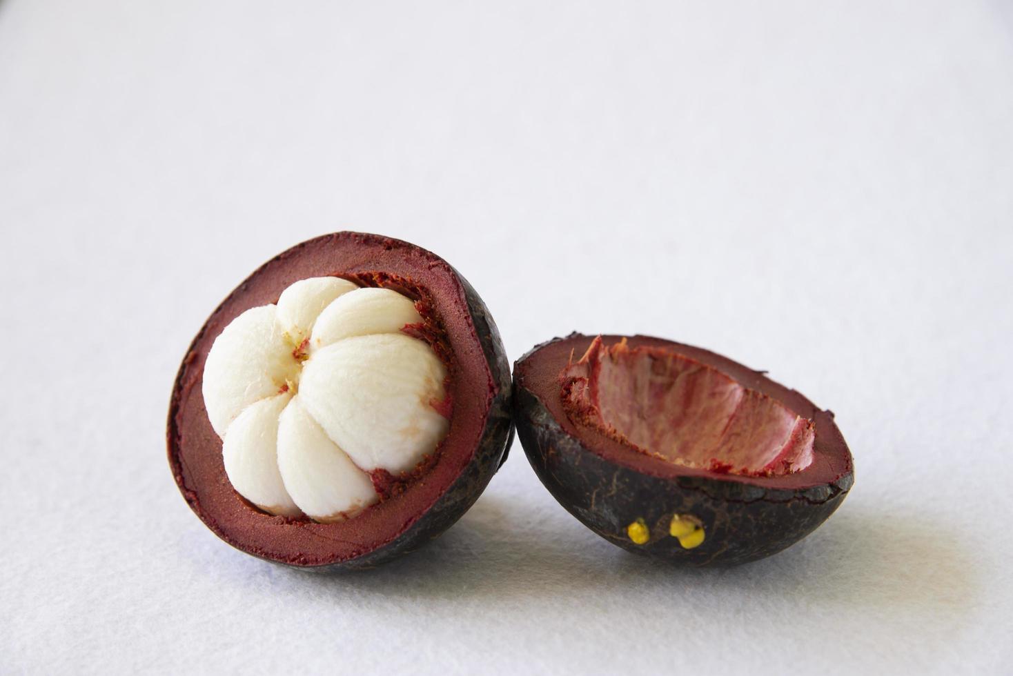 frutas populares tailandesas de mangostão - uma fruta tropical com segmentos brancos suculentos doces de carne dentro de uma casca marrom-avermelhada grossa. foto