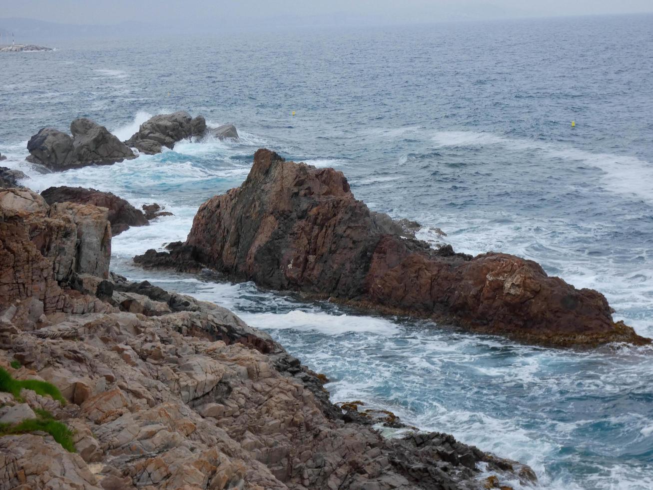 mar agitado, ondas batendo contra as rochas foto