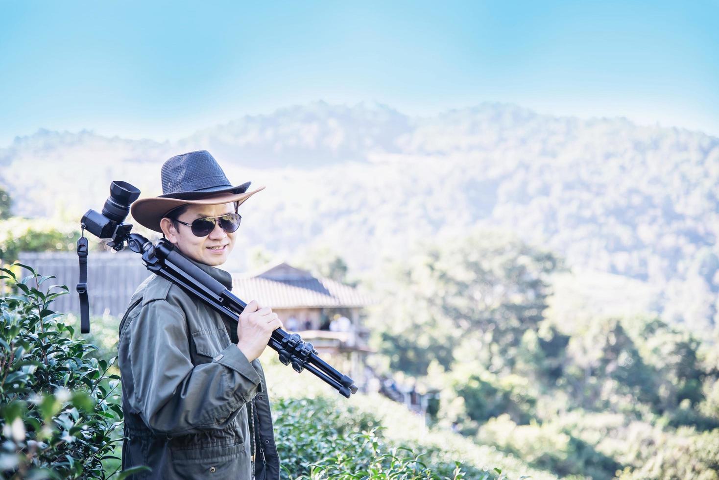 homem fotógrafo na natureza do campo de chá verde foto