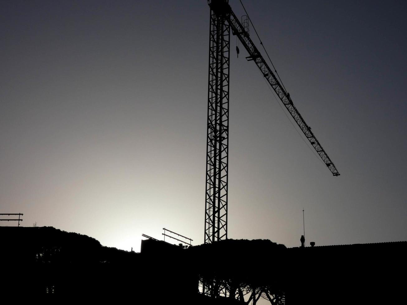 guindaste no trabalho em um canteiro de obras transportando materiais foto