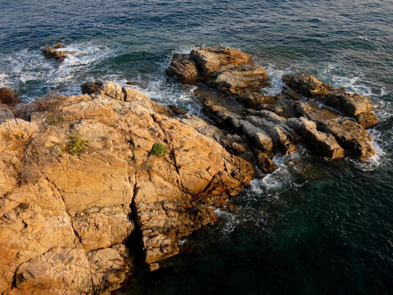 mar agitado, ondas batendo contra as rochas foto