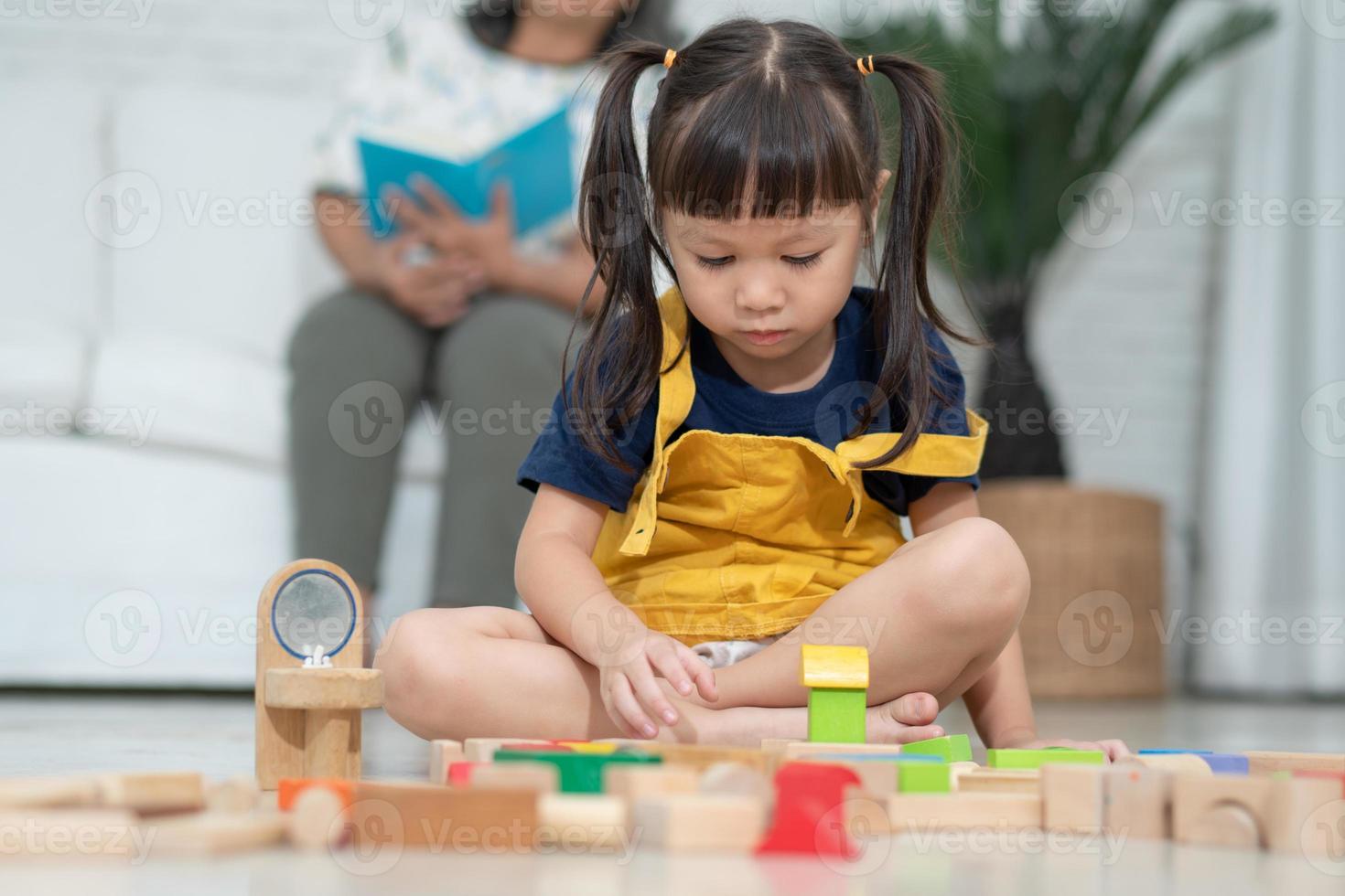 menina asiática bonitinha brincando com blocos de brinquedos coloridos, crianças brincam com brinquedos educativos no jardim de infância ou creche. jogo criativo do conceito de desenvolvimento infantil, criança criança no berçário. foto