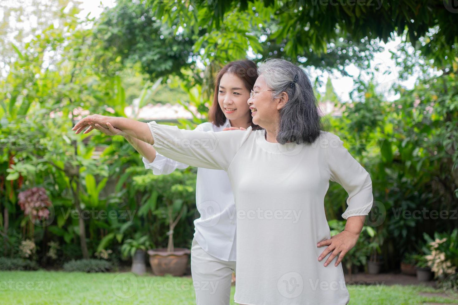 uma velha idosa asiática e se exercita no quintal com a filha. conceito de aposentadoria feliz com cuidados de um cuidador e poupança e seguro de saúde sênior, família feliz foto