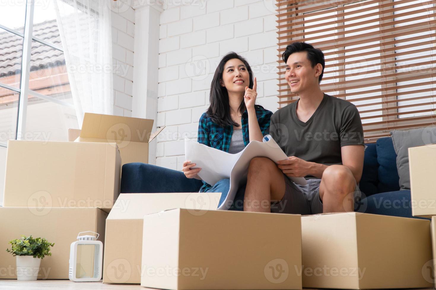 sorrindo, jovem casal feliz asiático segura o modelo para idéias de decoração para casa no dia da mudança em sua nova casa depois de comprar imóveis. conceito de começar uma nova vida para um casal recém-casado. foto