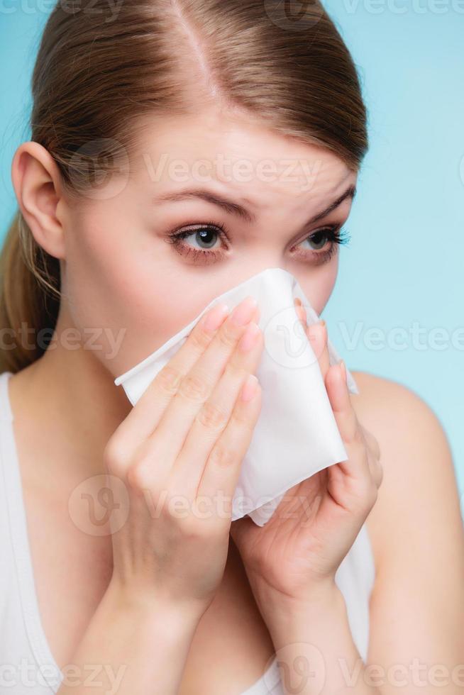 alergia à gripe. garota doente espirros em tecido. saúde foto
