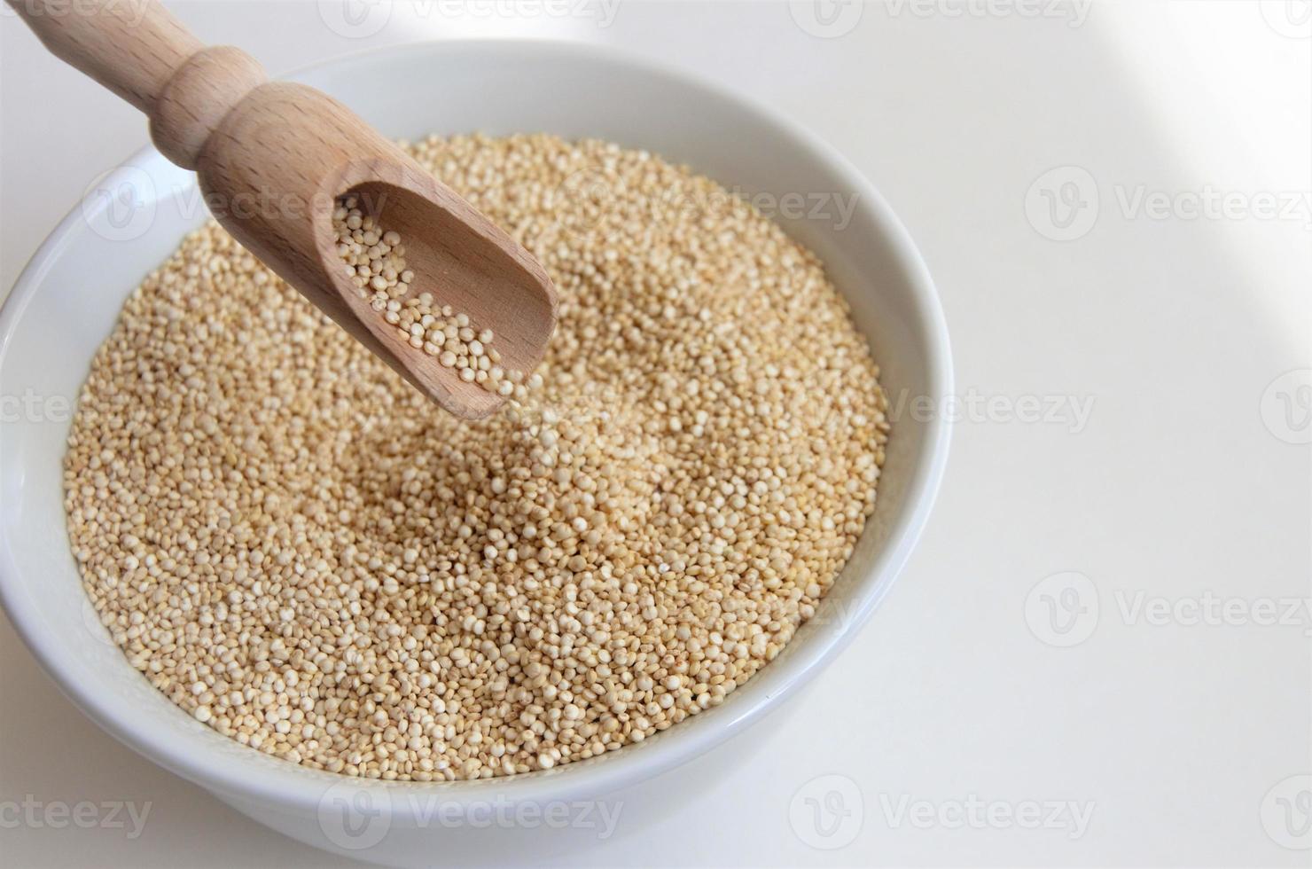 semente de quinoa para uma alimentação saudável em um prato branco com uma colher foto