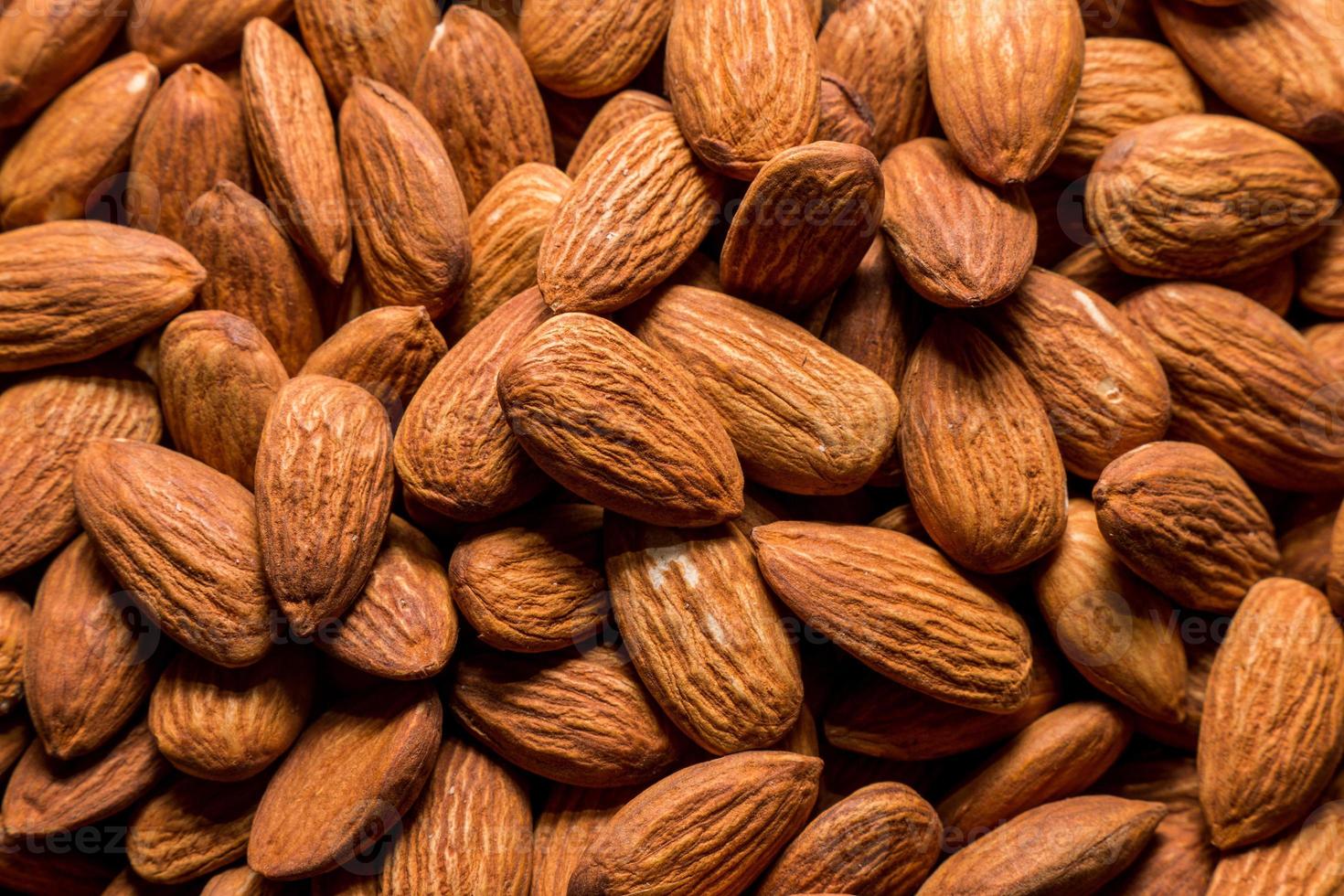 fundo de nozes de amêndoa inteira. lanche saudável vegetariano. comida orgânica. dieta vegetal. foto de alta qualidade