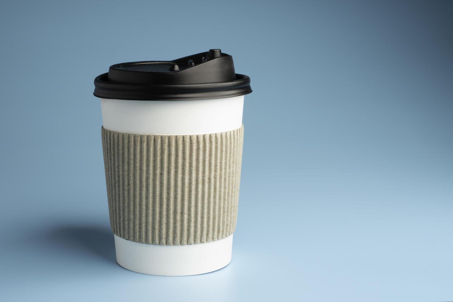 xícara de café de papel em fundo azul foto