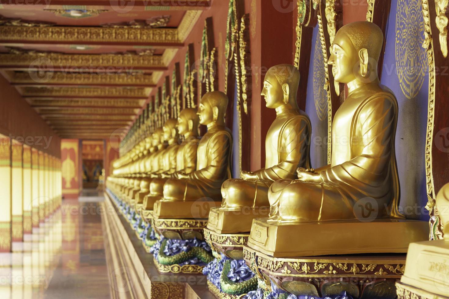 fileira da estátua de Buda dourada em wat bang thong, krabi, tailândia foto