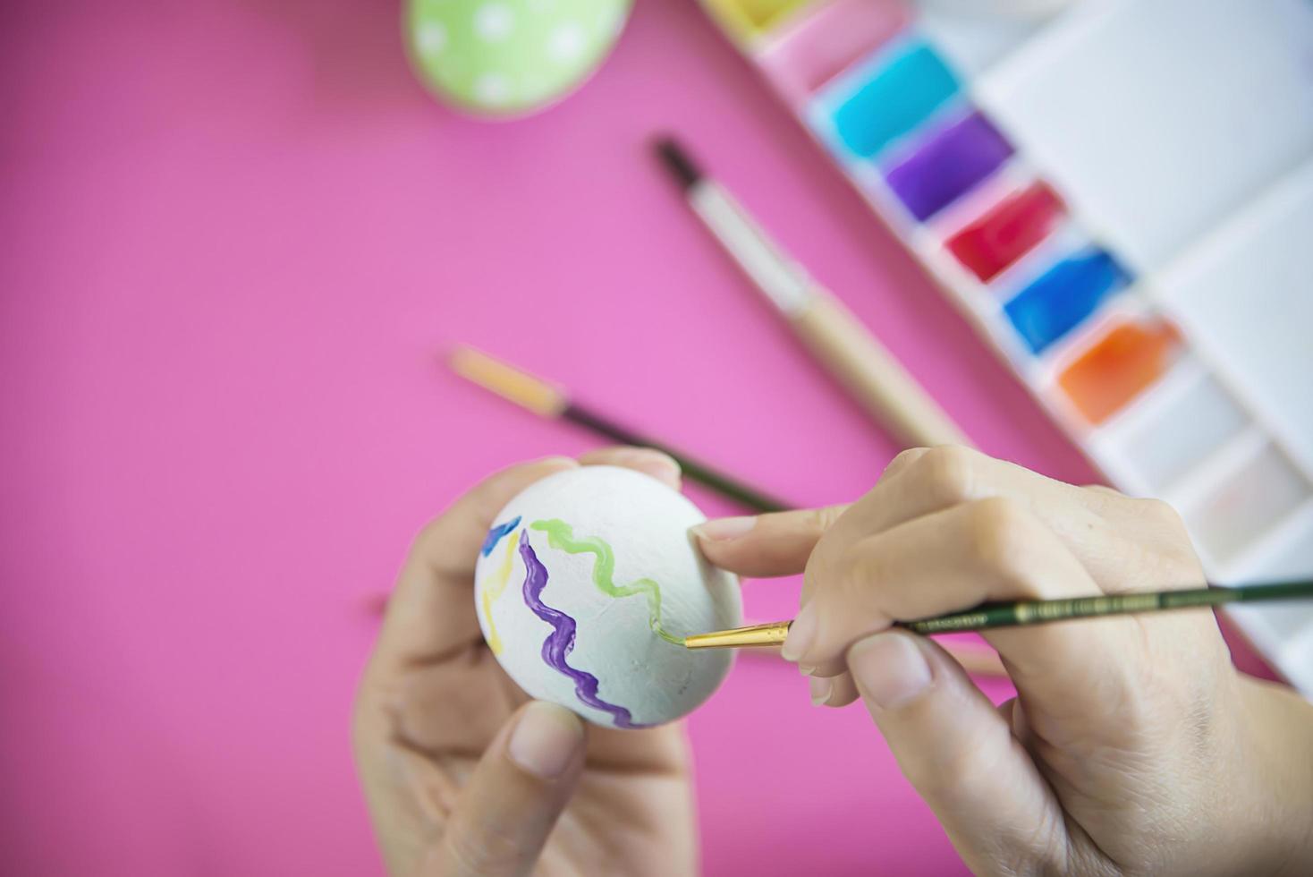 pessoas pintando ovos de páscoa coloridos - conceito de celebração do feriado de páscoa foto