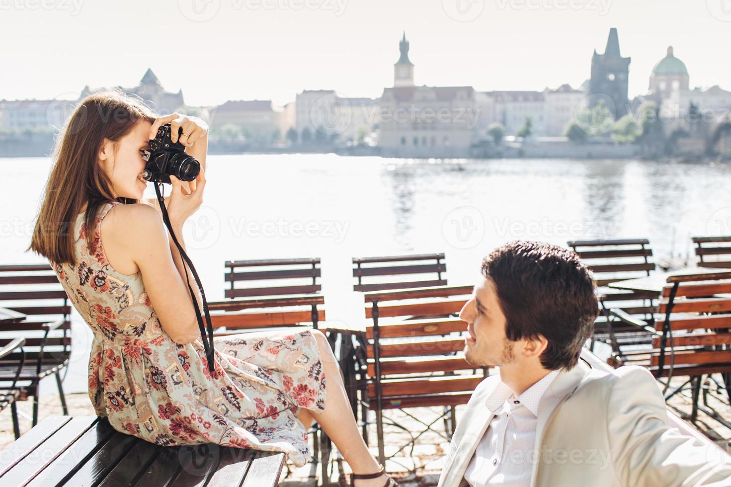 macho bonito posa para a câmera, estando de bom humor, passa o tempo livre com a namorada que o fotografa, paisagem maravilhosa ao fundo. turistas ativos femininos e masculinos vão passear juntos foto