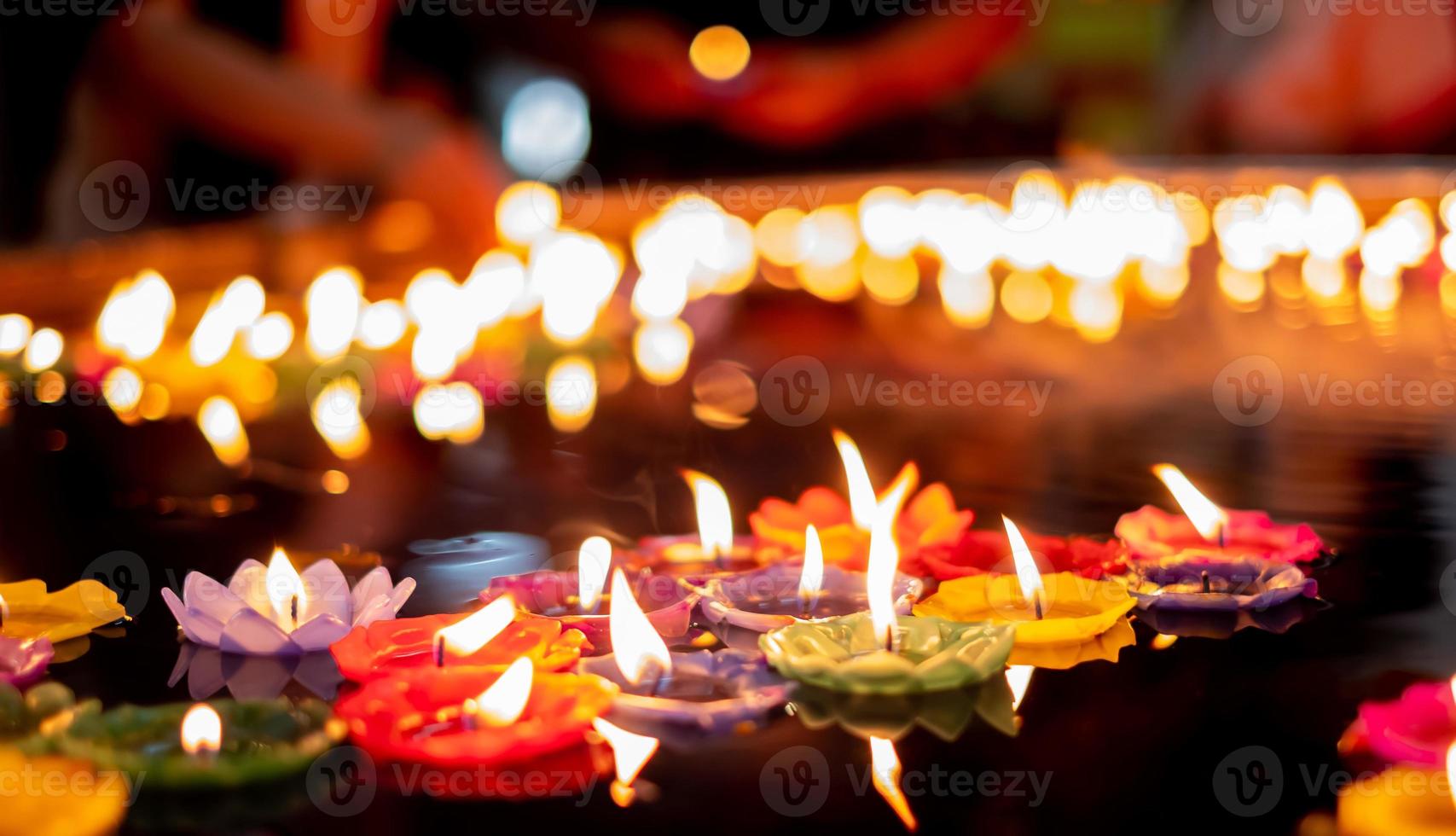 acenda uma pequena vela multicolorida no templo para orar pelas bênçãos sagradas foto