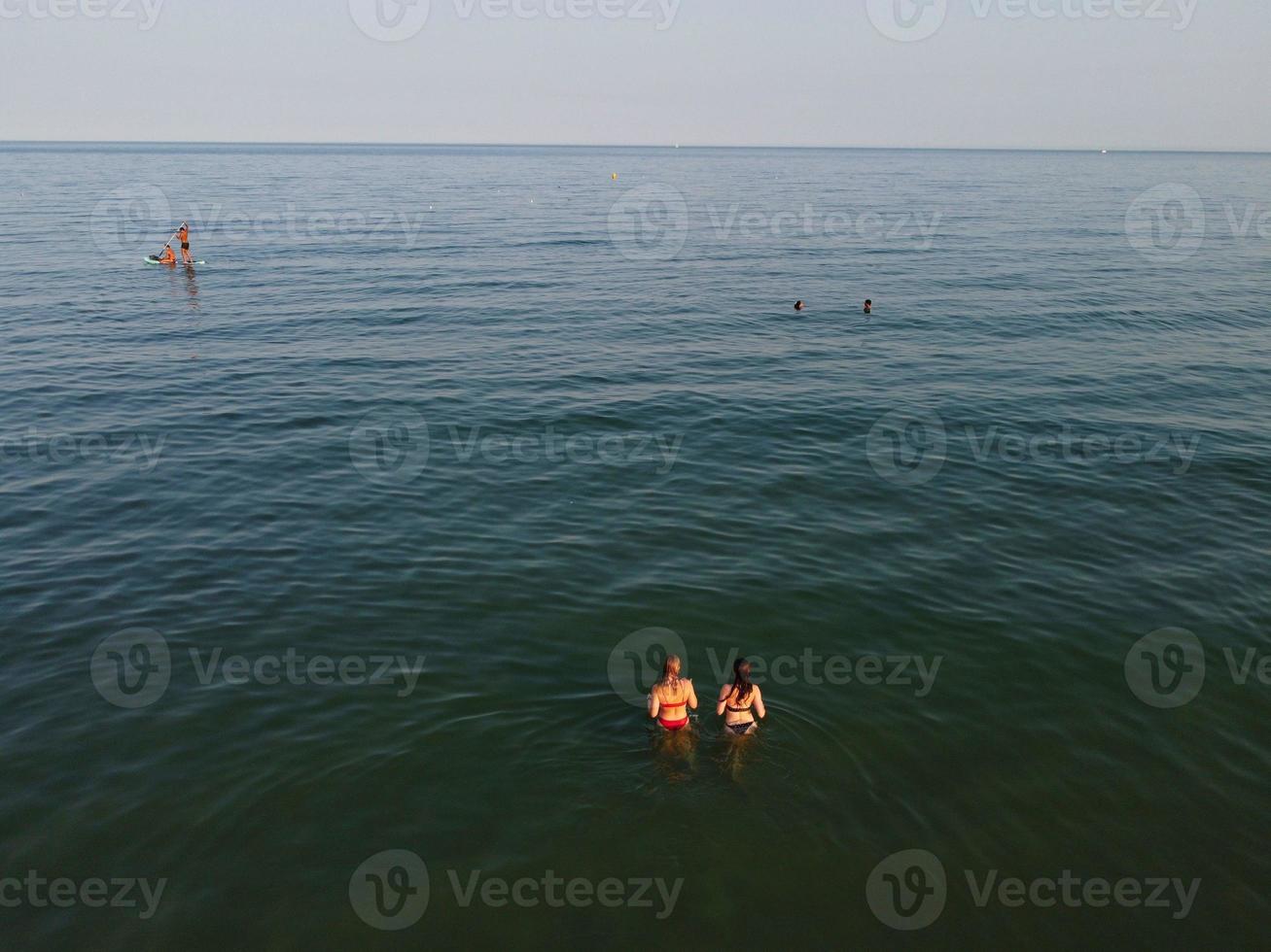 Vista de alto ângulo para o mar em frente à praia com pessoas na cidade de bournemouth, na inglaterra, reino unido, imagens aéreas do oceano britânico foto