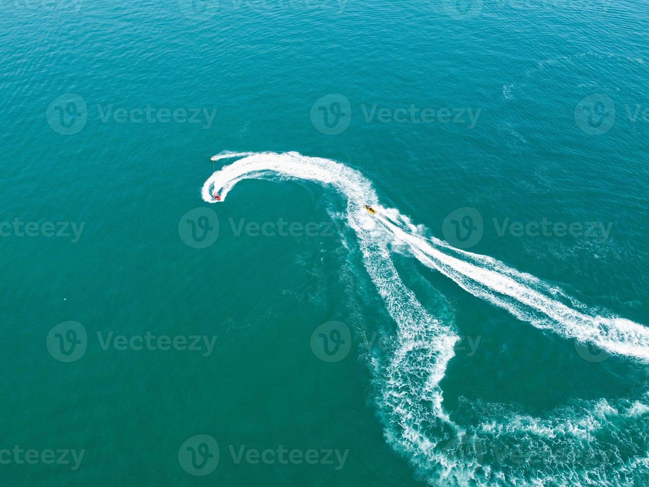 filmagens de alto ângulo e vista aérea do oceano com barcos de alta velocidade, as pessoas estão se divertindo e aproveitando o clima mais quente na frente do mar de bournemouth beach, na inglaterra, reino unido. foto