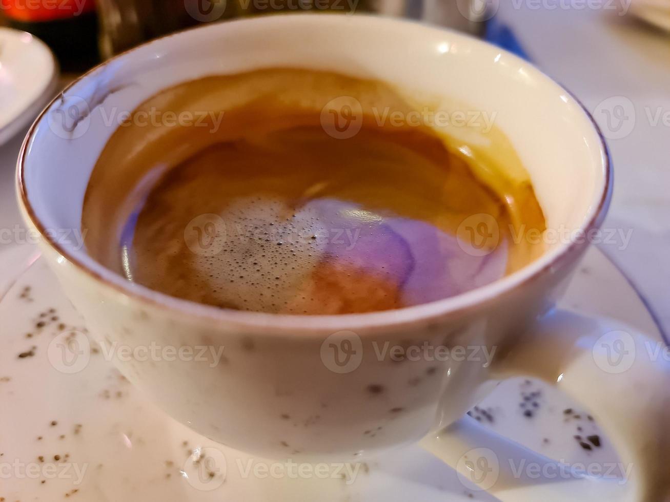 vista de foco seletivo em uma superfície de café em uma xícara branca foto