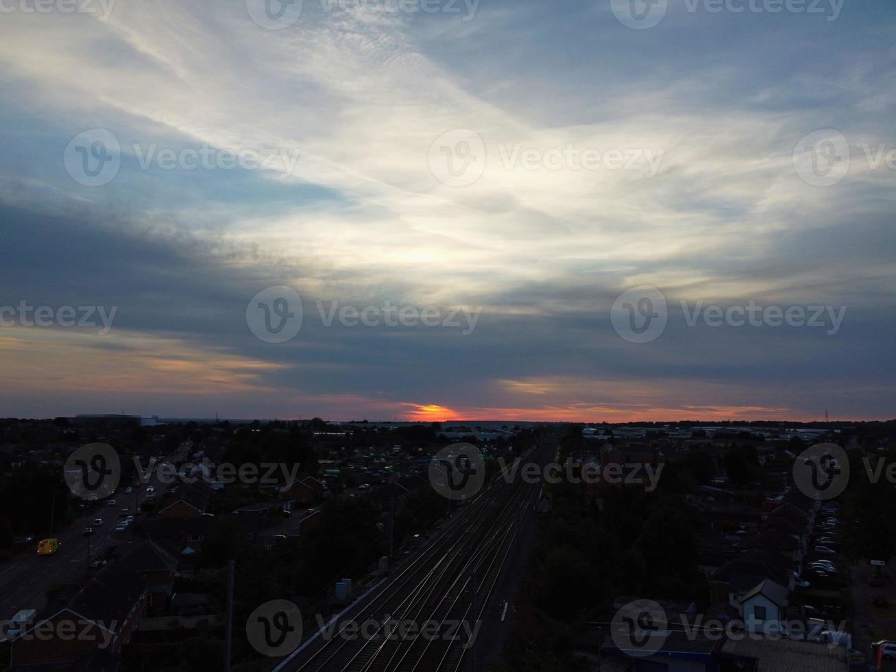 vista de alto ângulo de imagens aéreas da cidade de luton da inglaterra e estação ferroviária e trem em trilhos ao pôr do sol foto