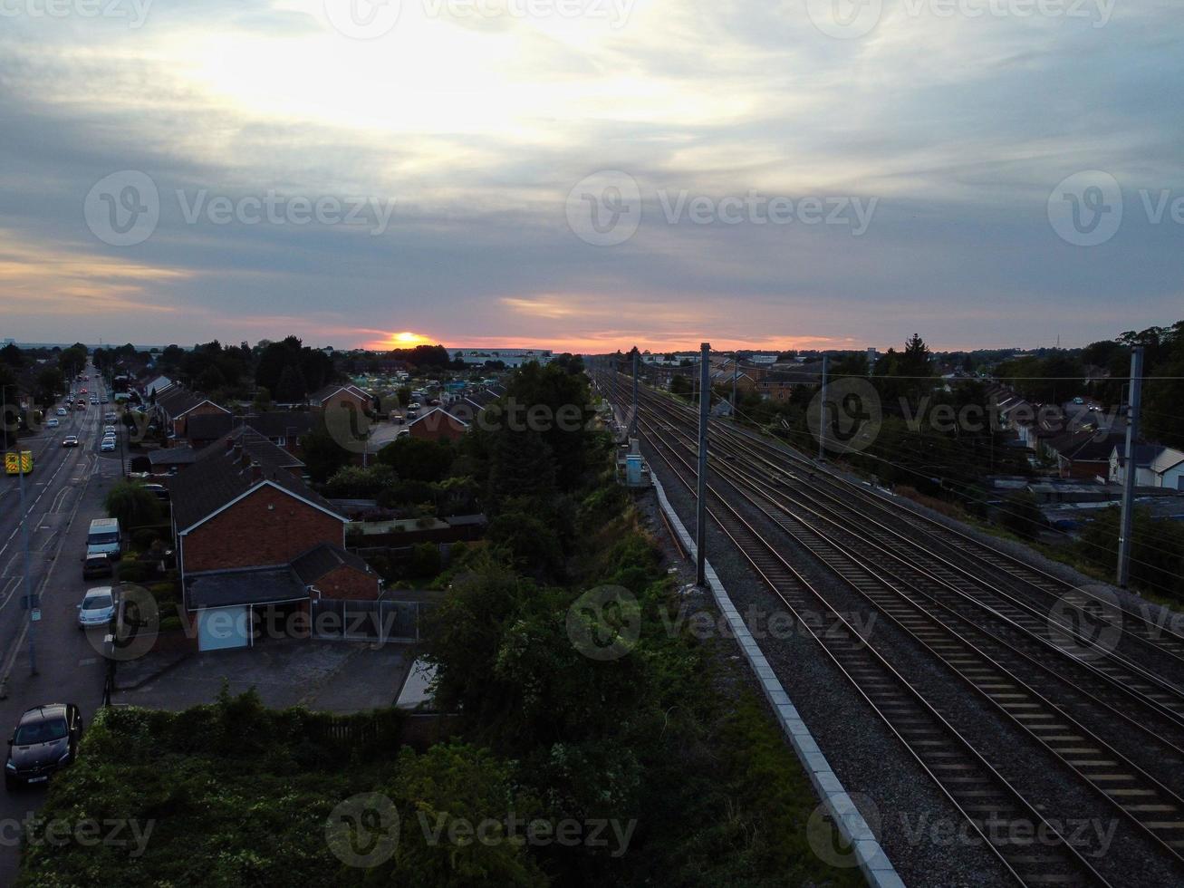 vista de alto ângulo de imagens aéreas da cidade de luton da inglaterra e estação ferroviária e trem em trilhos ao pôr do sol foto