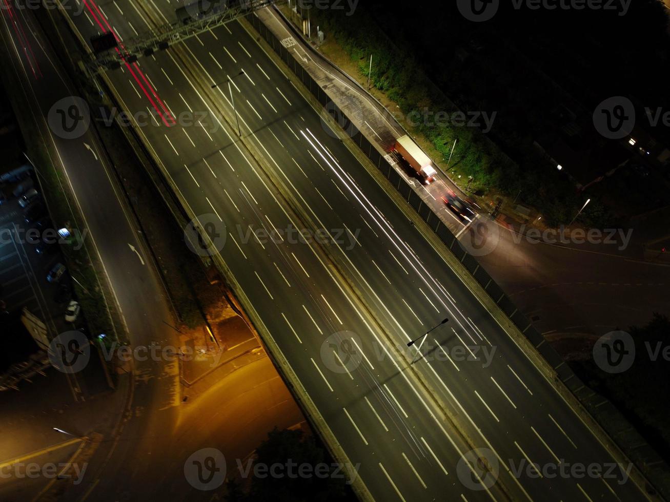 bela vista aérea de alto ângulo das autoestradas britânicas e tráfego na cidade de luton da inglaterra reino unido à noite após o pôr do sol foto