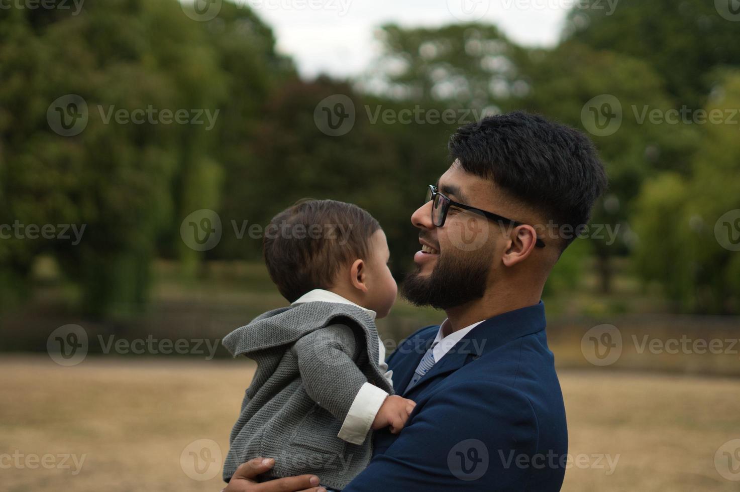 pai paquistanês asiático está segurando seu bebê de 11 meses no parque local foto