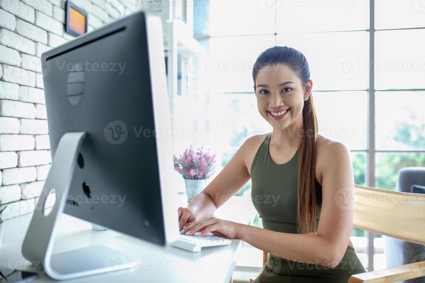 jovem mulher asiática usando computador portátil verificando o aplicativo de mídia social no site on-line em casa, sinta-se relaxado e aproveite para se comunicar e discutir na sala de estar. foto