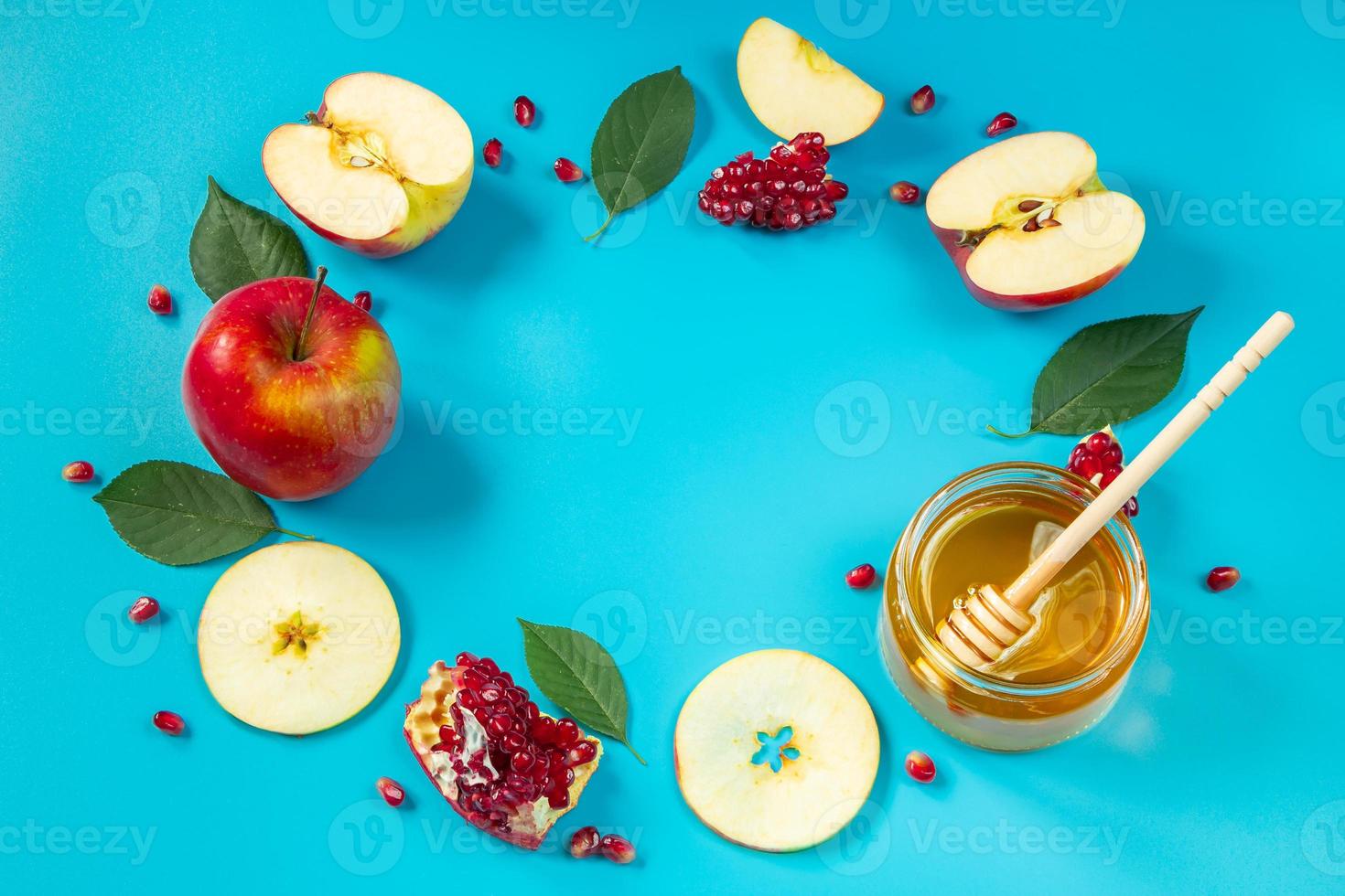 feliz Rosh Hashaná. mel, maçãs e romãs sobre fundo azul. moldura redonda para o seu texto. feriado religioso tradicional judaico. foto