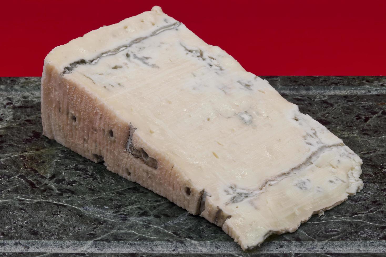 fatia de queijo gorgonzola italiano isolado na mesa de mármore verde foto