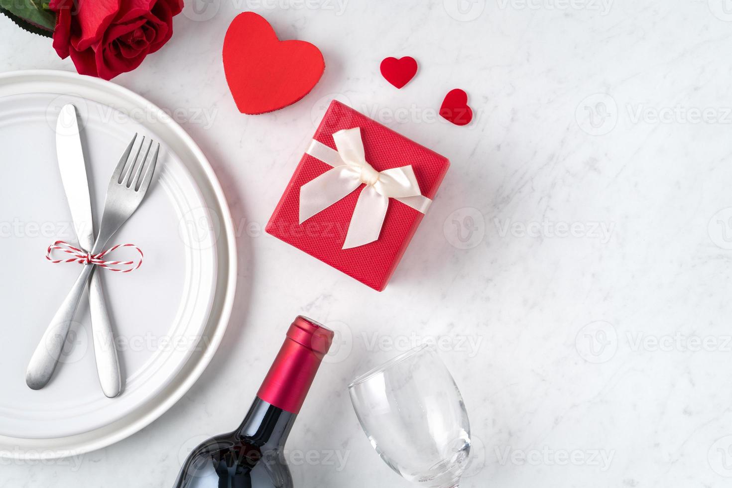 prato com talheres, fita, presente e rosas para o conceito de refeição especial de dia dos namorados. foto