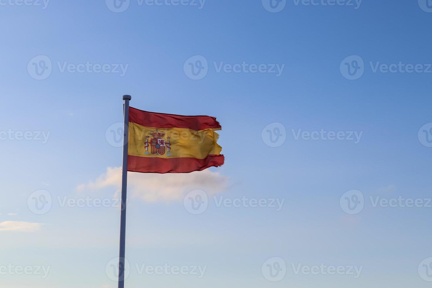 bandeira da espanha em um mastro movendo-se lentamente ao vento contra o céu foto