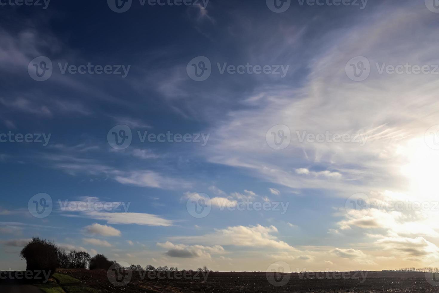 belas nuvens em um céu azul sobre um campo agrícola do norte da Europa. foto