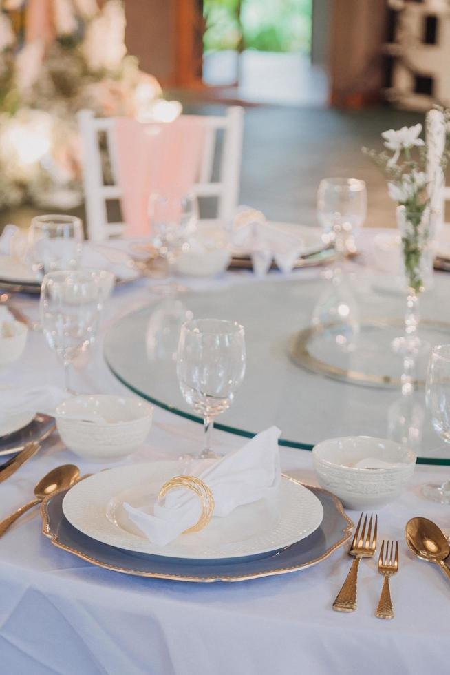 arranjo de flores para casamento de verão, feito de rosas e ramos verdes em uma mesa de jantar no restaurante. , vidro e pratos no restaurante do lado de fora em um dia ventoso com efeito de grão de filme foto