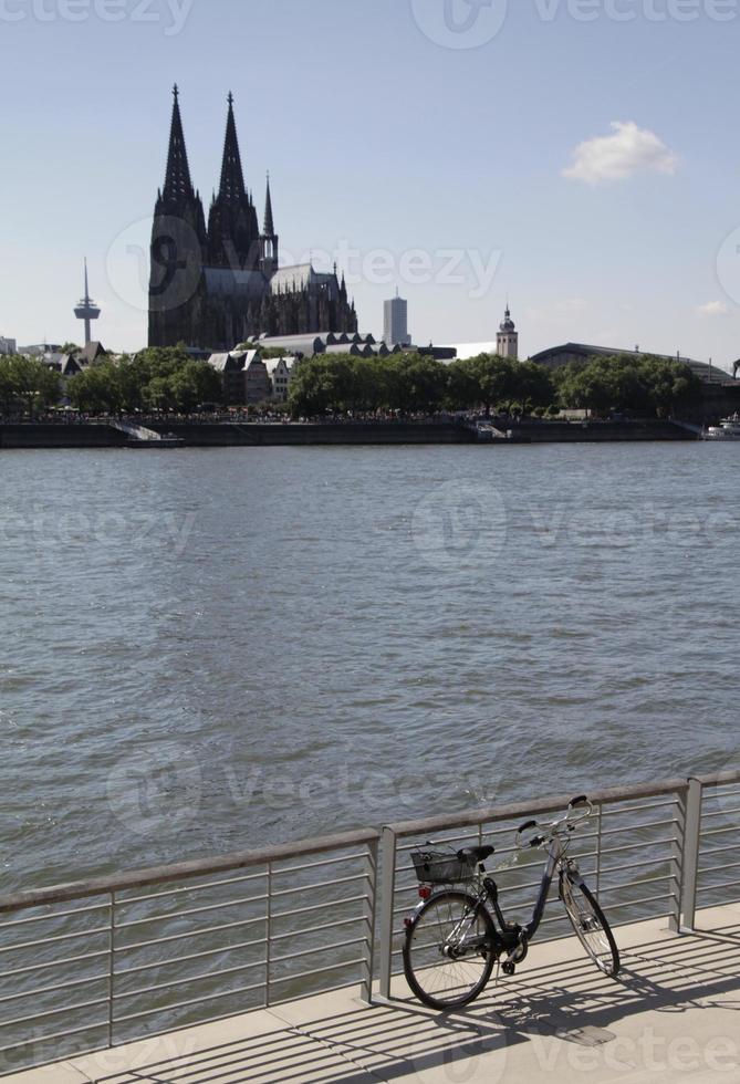 bicicleta no rio Reno com a Catedral de Colônia ao fundo foto