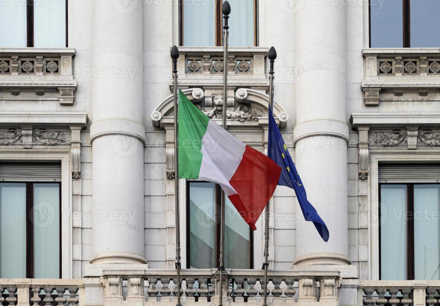 bandeira italiana pendurada ao lado da bandeira da ue ao vento foto