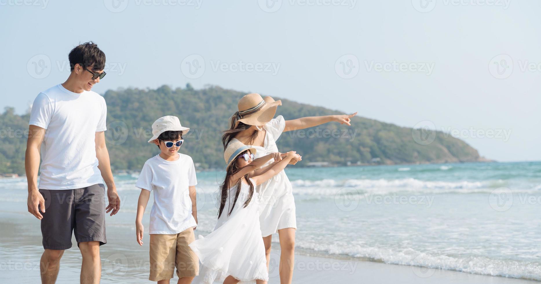 família asiática andando na praia com crianças conceito de férias felizes foto