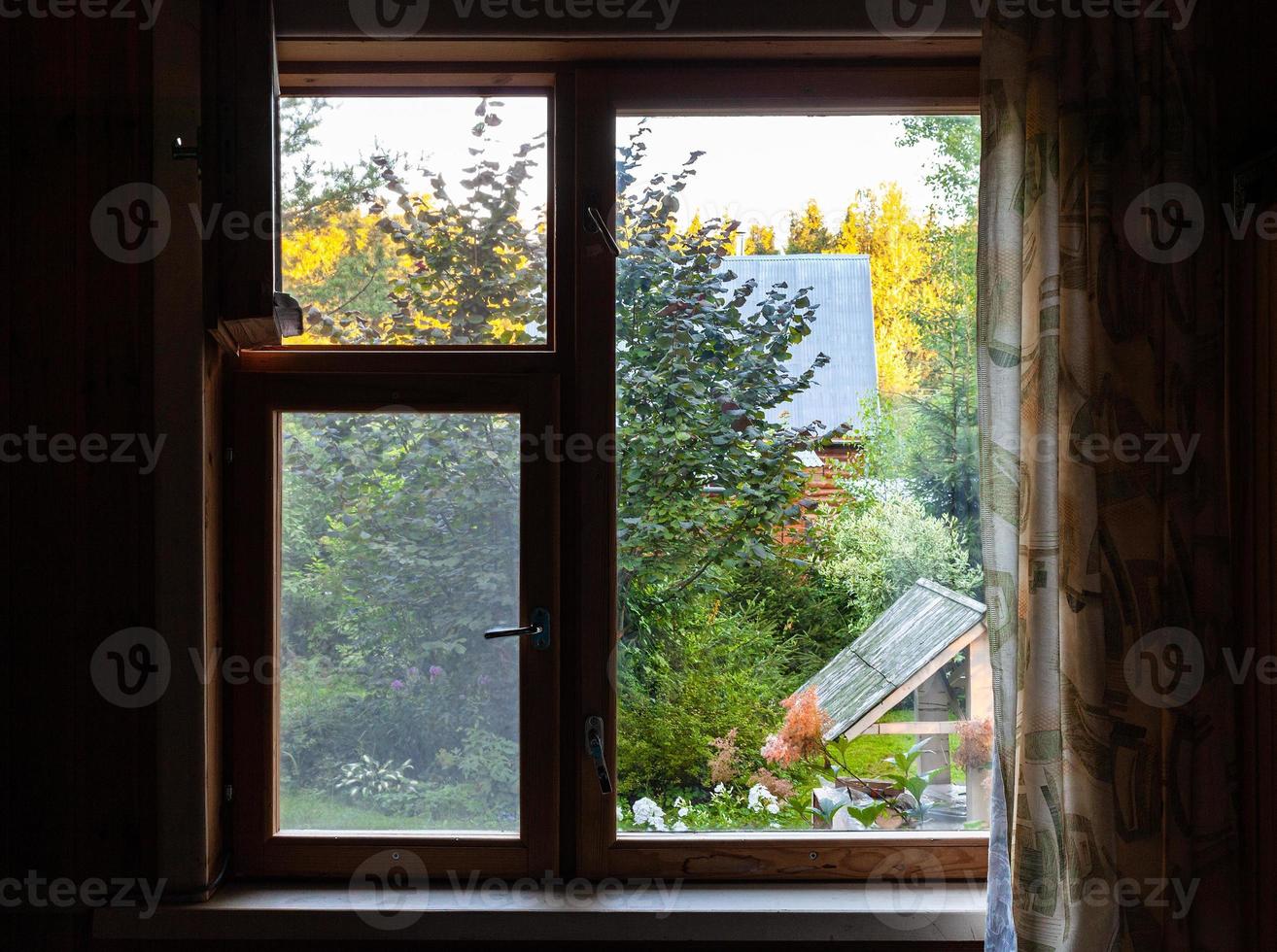 vista do quintal verde com poço pela janela foto