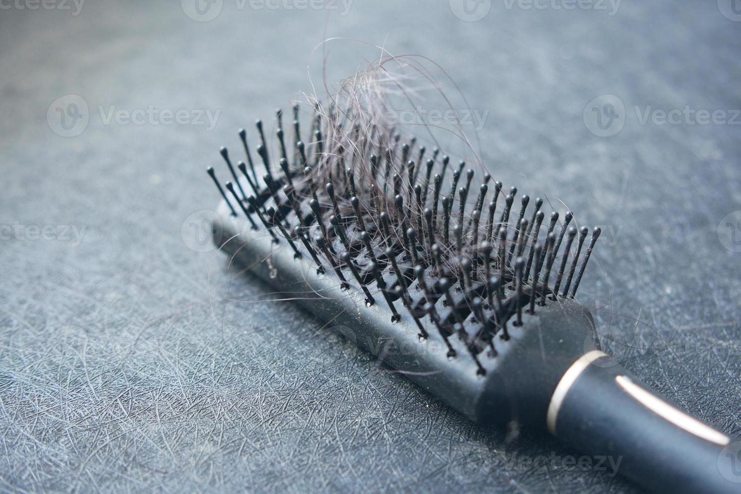 uma escova com cabelo perdido na mesa foto