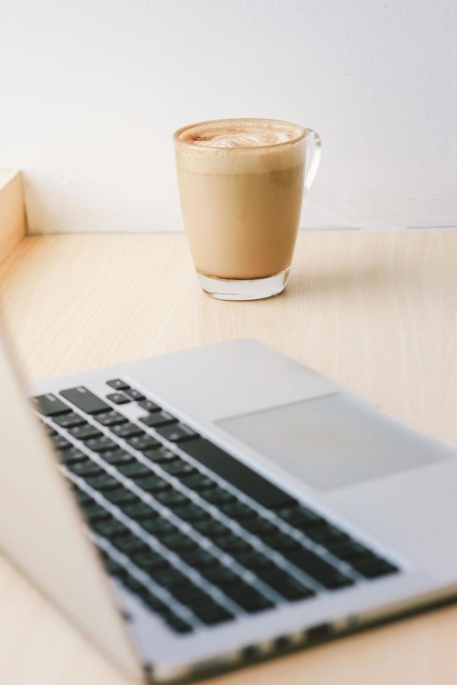 espaço de trabalho no café com computador laptop e café com leite, estilo de vida e conceito de negócios foto