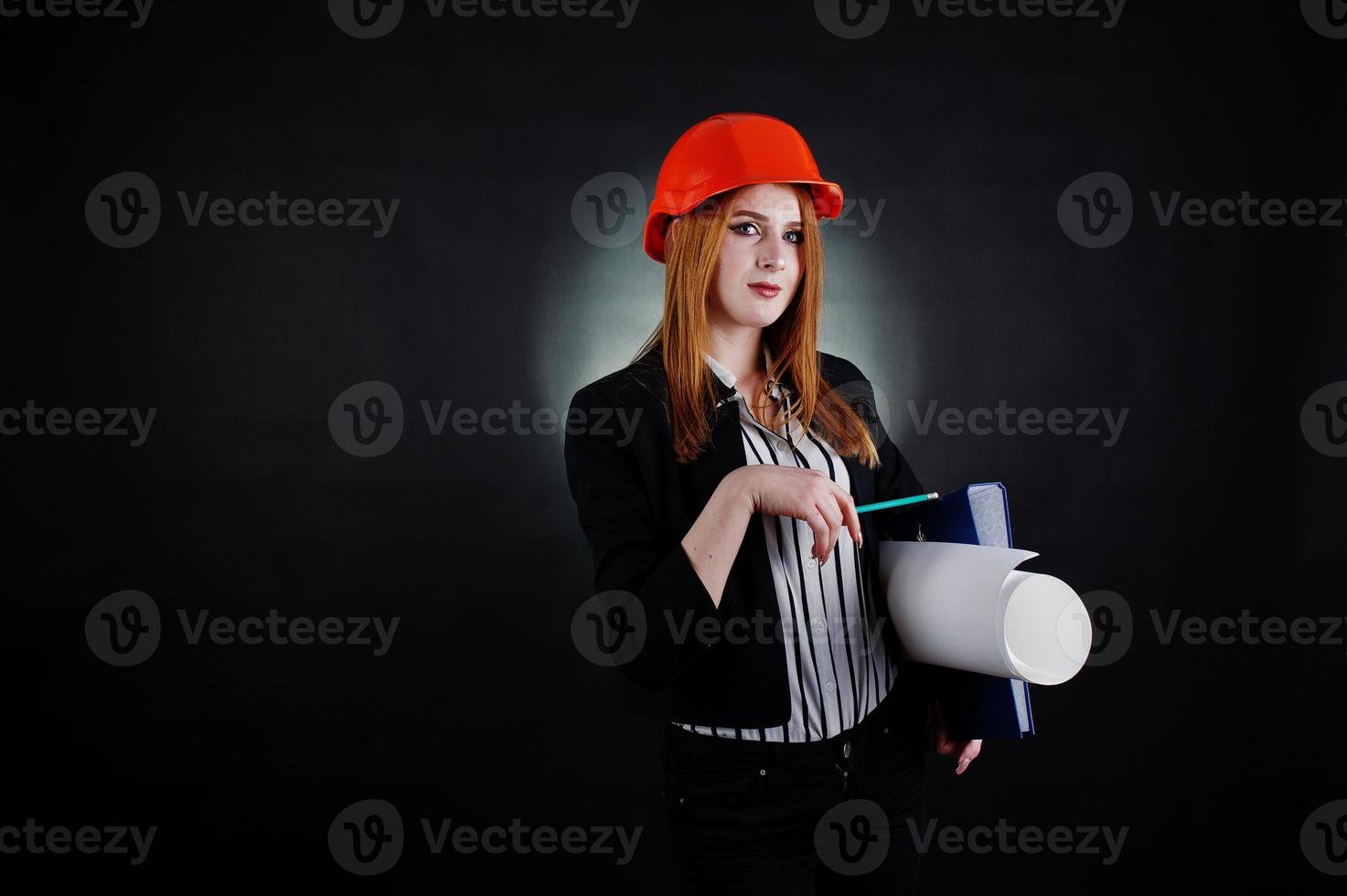 mulher engenheira em laranja proteger capacete com projeto de papel de construção. foto