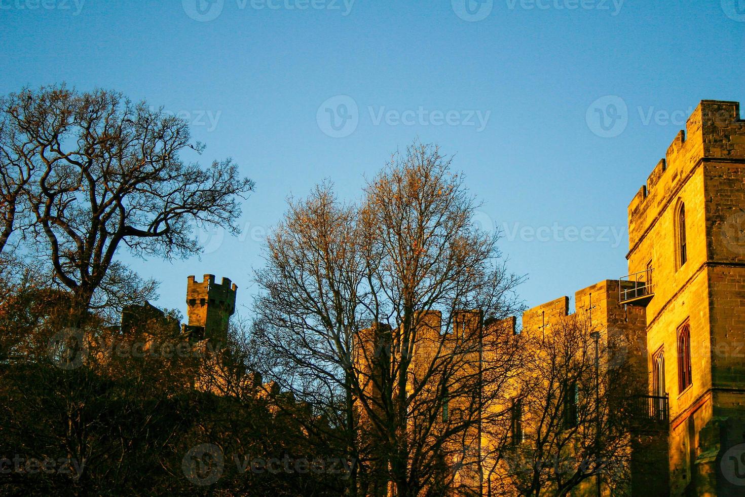 antigo castelo de construção arquitetônica medieval europeu na luz dourada do outono com o fundo do céu azul durante o outono foto