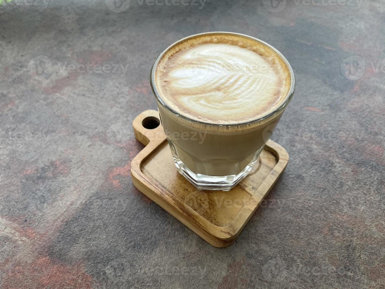 bela xícara de café cappuccino com latte art no fundo do espaço de madeira foto