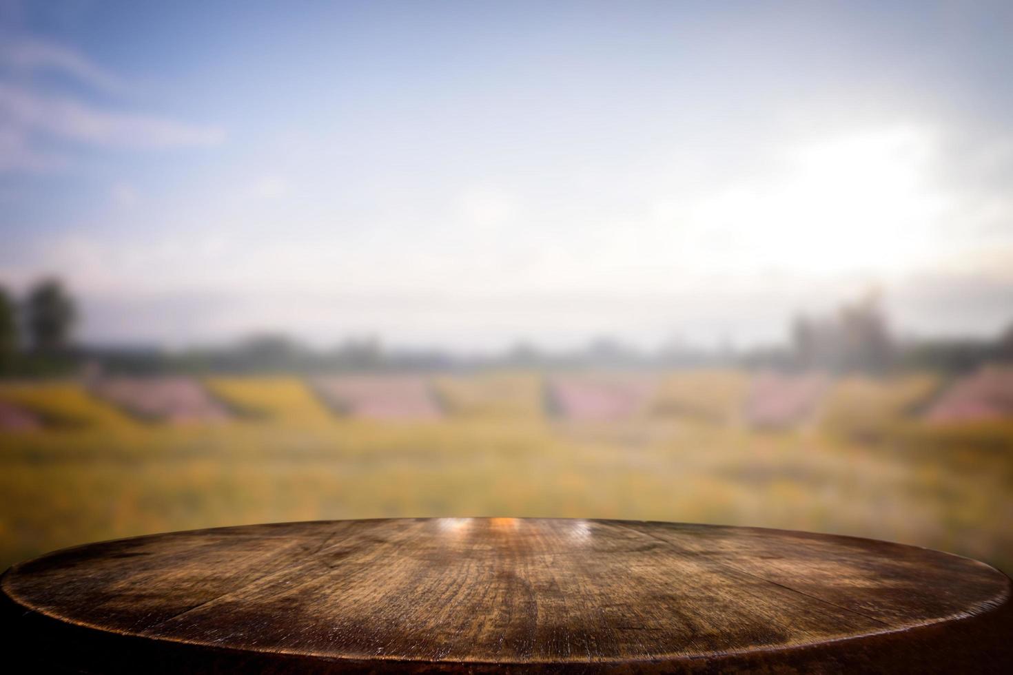 mesa de madeira vazia de foco selecionado e vista de muitas flores desfocam o fundo com imagem bokeh. para sua fotomontagem ou exposição de produtos. foto