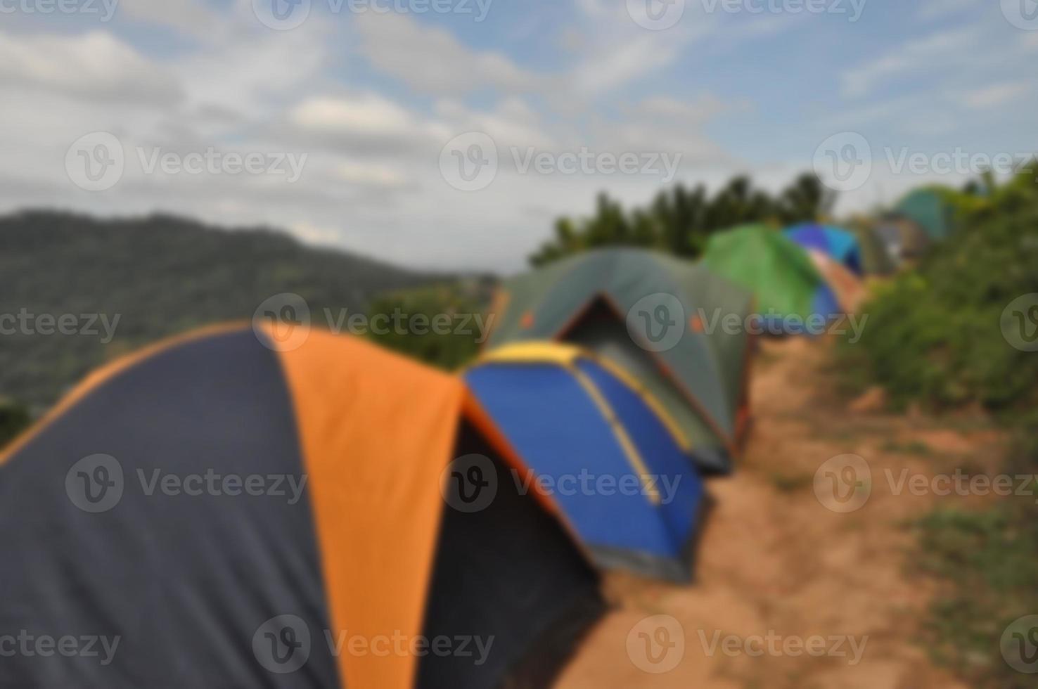 muitas pessoas armam barracas em atrações de montanha durante a longa temporada de férias - desfoque a imagem para o fundo foto