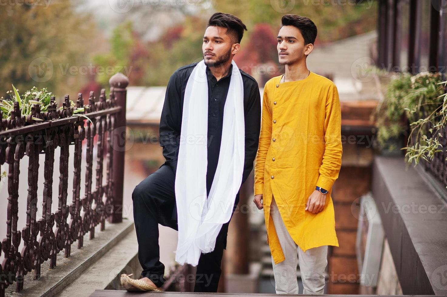 dois amigos indianos elegantes em roupas tradicionais posaram ao ar livre. foto