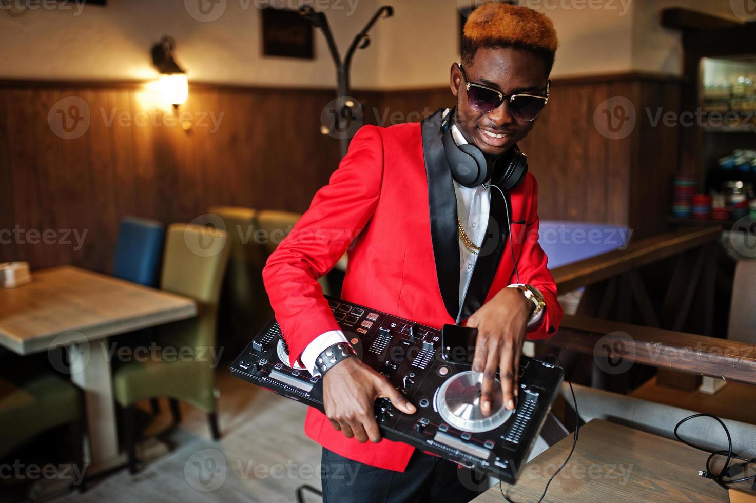 moda homem afro-americano modelo dj no terno vermelho com controlador de dj. foto