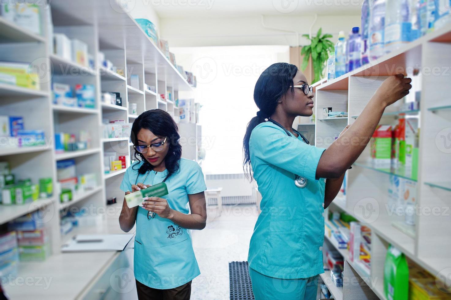 dois farmacêuticos afro-americanos trabalhando em drogaria na farmácia hospitalar. saúde africana. foto